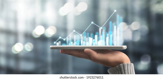 Businessman plan graph growth and increase of chart positive indicators in his business,tablet in hand - Shutterstock ID 1923276011