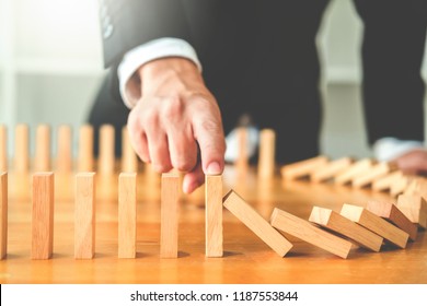 Businessman plan and strategy in business Domino Effect Leadership Management Solution concept - Shutterstock ID 1187553844