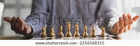 Businessman planning strategy with chess figures on wooden table.
