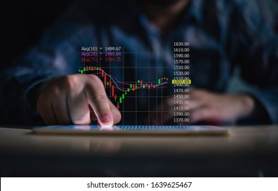 Businessman playing tablet and showing a growing of statistics, graph and chart with arrow up on dark background. - Shutterstock ID 1639625467