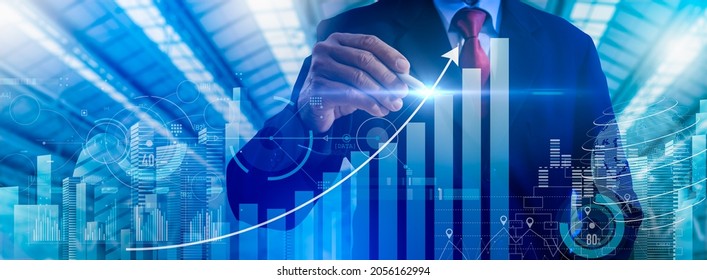 Businessman point to growthing graph and modern computer virtual dashboard analyzing finance sales data and economic growth graph chart and block chain technology.