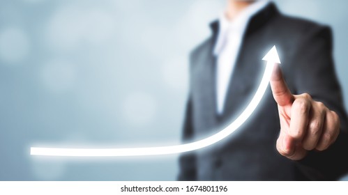 Businessman pointing arrow graph corporate future growth plan. Business development to success and growing annual revenue growth concept - Shutterstock ID 1674801196