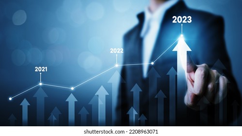 Businessman pointing arrow graph corporate future growth plan. Business development to success and growing growth year 2022 to 2023 concept - Shutterstock ID 2208963071