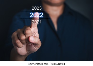 Businessman pointing to digital 2022 calendar. Countdown to 2022 concept. Space for text.