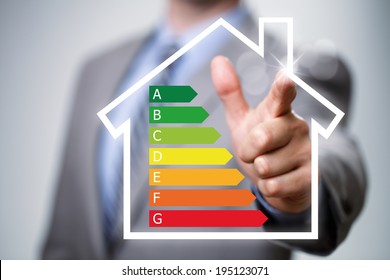 Businessman pointing to energy efficiency rating chart and house icon concept for performance, efficiency and environmental conservation