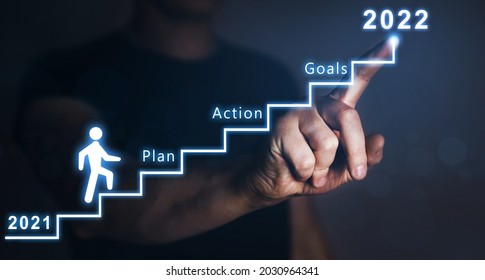Businessman pointing to the growing plan of successful business in 2022 year and a figure climbs the ladder of success. Year 2022 plan, action and goals.  - Shutterstock ID 2030964341