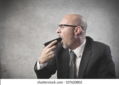 Businessman pointing a gun in his mouth