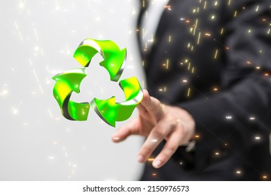 A businessman pointing to a hovering gree recycle icon against a blurred background