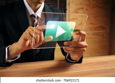 businessman pointing at a movie playback button. - Powered by Shutterstock