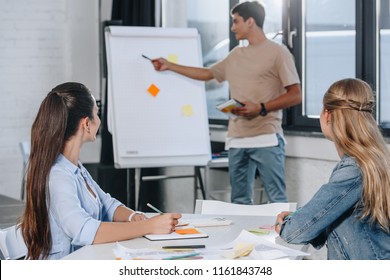 businessman pointing on flipchart during presentation in office