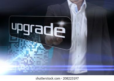 Businessman pointing to word upgrade against shiny barcode on black background