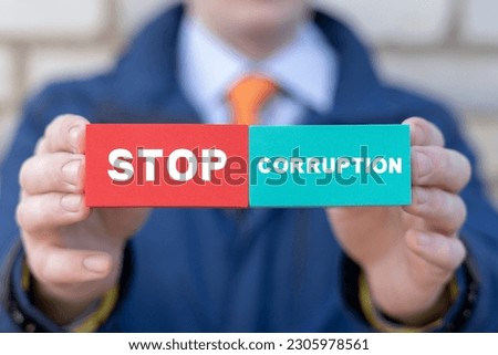 Businessman or politician holding colorful blocks with inscription: STOP CORRUPTION. Concept of stop bribery and corruption. Illegal corrupt activity. Anti-corruption. AML.