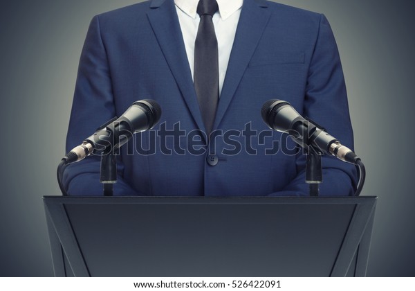 Businessman or politician making speech from\
behind the pulpit