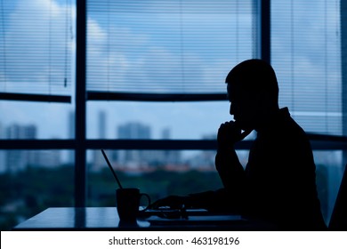 Businessman pondering over new idea in dark office - Shutterstock ID 463198196