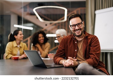 Businessman posing for the camera, being with his female colleagues at the office. - Shutterstock ID 2232132701
