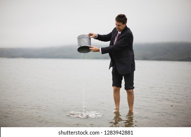 Businessman Pouring Water Out Of Bucket