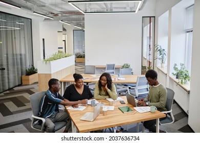 Businessman presenting his creative idea to colleagues at meeting and showing documents with marketing data - Shutterstock ID 2037636734