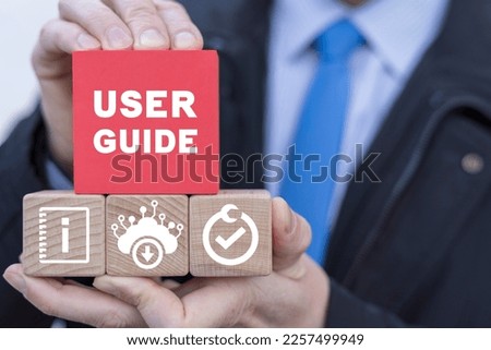 Businessman presents colorful blocks with banner: USER GUIDE. Download online user manual book.