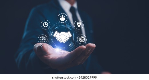 A businessman presents a holographic global partnership concept, with interconnected icons floating above his hand. Business partnerships concept. Business collaboration strategies. - Powered by Shutterstock