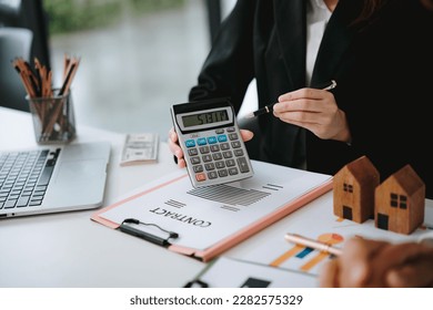 Businessman press calculator to calculate to analyze investment strategies and brainstorm sales plans for a more profitable business. - Shutterstock ID 2282575329
