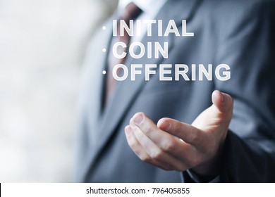 Businessman presses button ICO Initial Coin Offering on virtual digital electronic user interface.