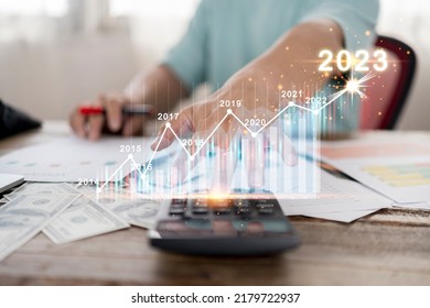 Businessman presses a calculator to analyze investment calculations. growth chart graph diagram Income plan investment cash money and stock market new year 2023