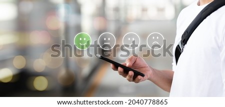 Businessman presses a smartphone Laughing icons on the virtual screen, such as assessments, polls, recommendations, and preferences.