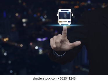 Businessman Pressing Bus Flat Icon Over Blur Colourful Night Light City Tower Background, Business Transportation Service Concept
