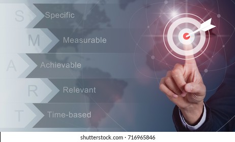 Businessman pressing button goal on virtual screen, Success concept, world maps on the background.