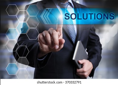 Businessman pressing button on touch screen interface and select "Solutions". Business concept. Internet concept.