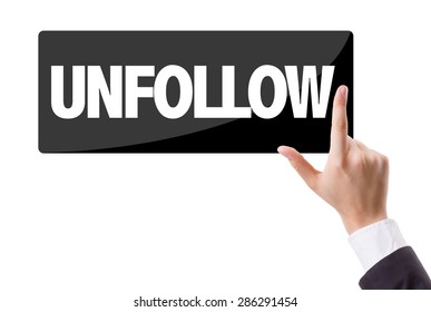 Businessman pressing button with the text: Unfollow