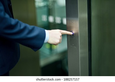 Businessman Pressing Elevator Button