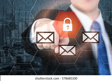 Businessman pressing e-mail security button on virtual screens for internet and e-mail security. Business, technology, internet and virtual reality concept.