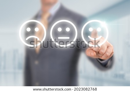 Businessman pressing excellent smiley face rating icon over light blue background, customer service evaluation and feedback rating concept. costumer review concept, man pointing on happy smiling face