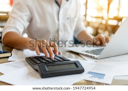 Businessman pressing on calculator for calculating cost estimating with laptop.