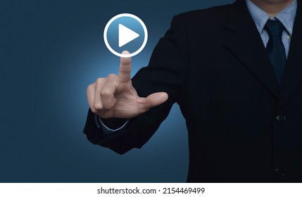 Businessman pressing play button icon over gradient light blue background, Business music online concept - Powered by Shutterstock