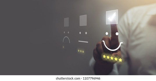 Businessman pressing smiley face emoticon on virtual touch screen. Customer service evaluation concept. - Shutterstock ID 1107796946