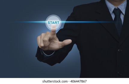 Businessman Pressing Start Button With Spot Light On Blue Background