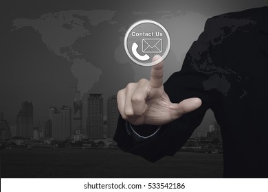 Businessman Pressing Telephone And Mail Icon Button Over World Map And City Tower, Contact Us Concept, Elements Of This Image Furnished By NASA
