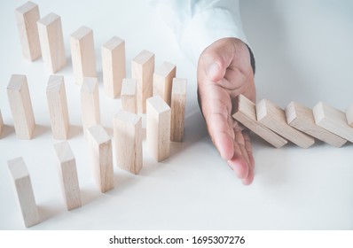 Businessman protect wooden block ,Business risks in the business. Requires planning Meditation must be careful in deciding to reduce the risk in the business.  - Shutterstock ID 1695307276