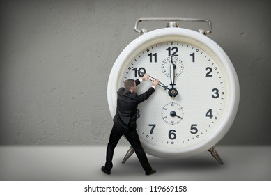 Businessman Pulling A Clock Hand Backwards