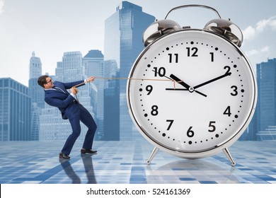 Businessman Pulling Clock In Time Management Concept