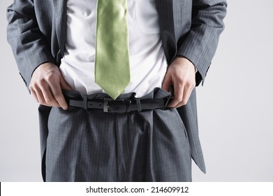 Businessman Pulling Up Pants And Fixing His Shirt On White Background