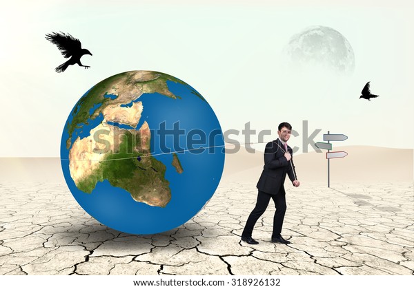Businessman pulls with rope world\
sphere in desert .Elements of this image furnished by\
NASA
