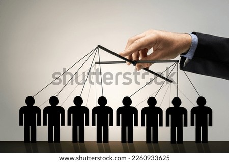 Businessman puppeteer manipulation, controls the paper figures of people with strings.
