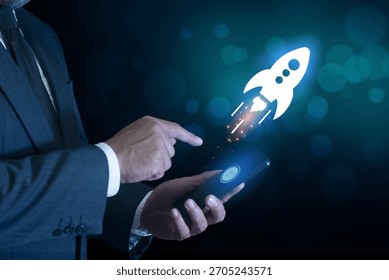 Businessman push button startup rocket or rocket ship launch on mobile phone or smartphone. idea of successful business project start up, boost technology, innovation.