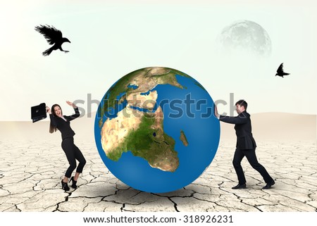 Businessman pushes world sphere in desert .Elements of this image furnished by NASA