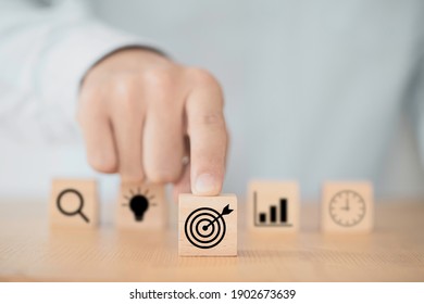 Businessman pushing target dartboard icon in front of others icons to setup business objectives. - Shutterstock ID 1902673639