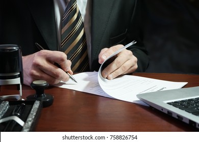 A businessman puts his signature on the contract