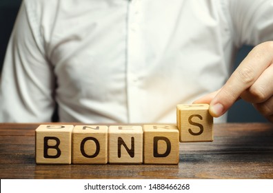 Businessman puts wooden blocks with the word Bonds. A bond is a security that indicates that the investor has provided a loan to the issuer. Equivalent loan. Unsecured and secured bonds.